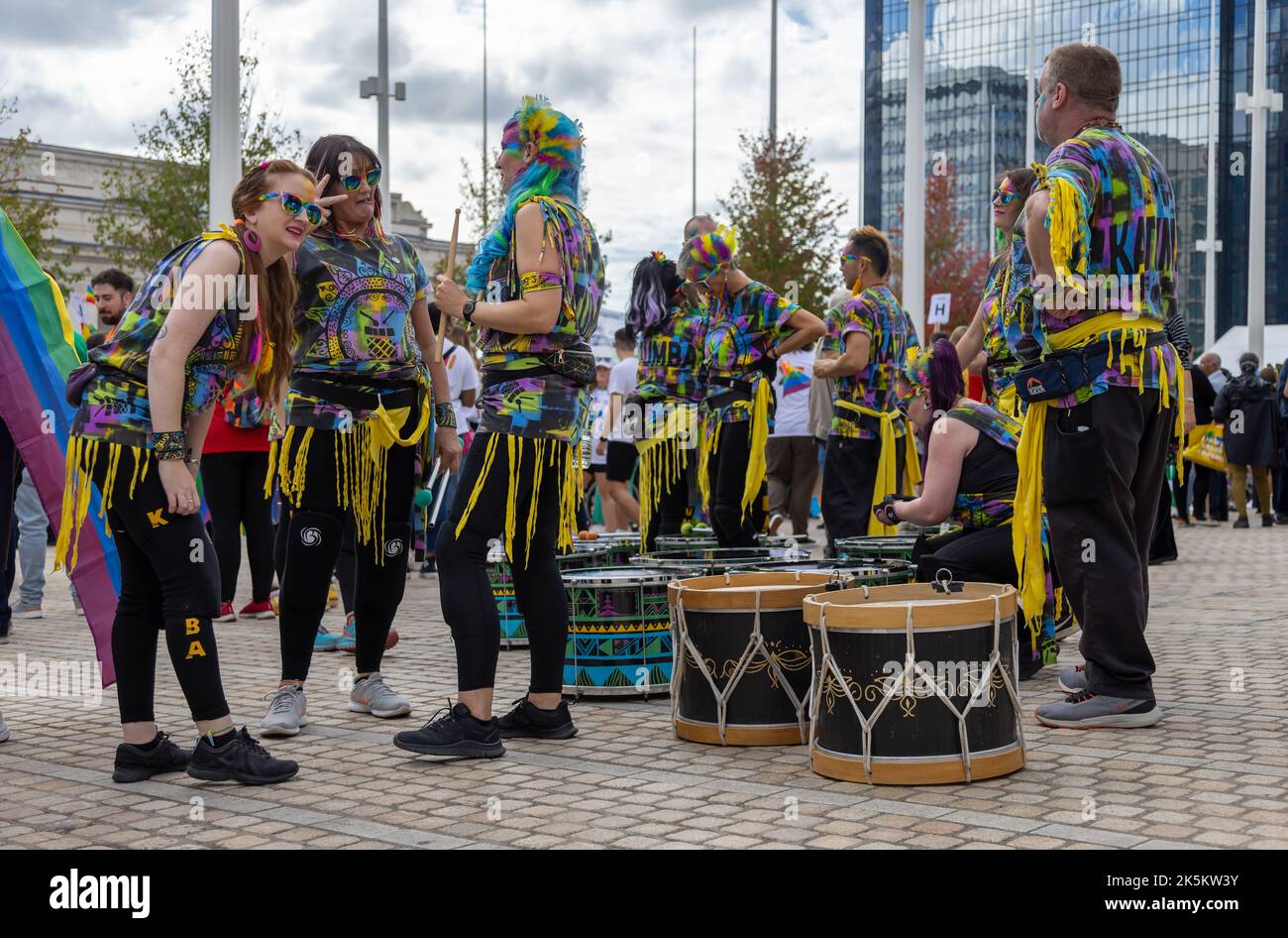 Die Katumba-Trommler stehen unter ihren Trommeln und unterhalten sich, während sie auf den Beginn der Parade im Birmingham Pride warten. Stockfoto