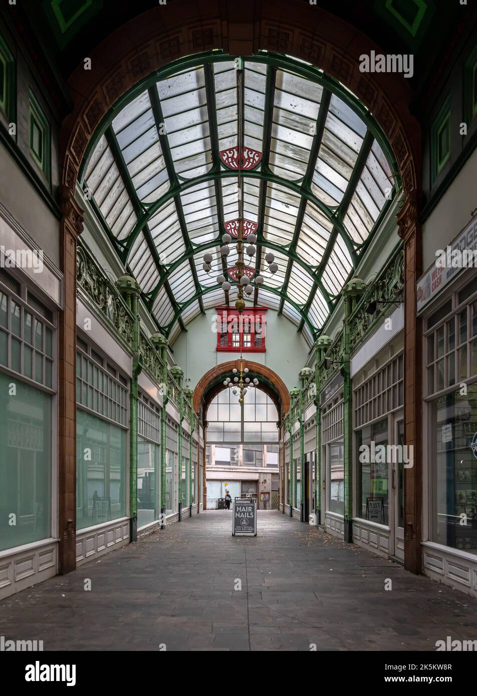 City Arcade ist eine viktorianische Einkaufspassage im Stadtzentrum von Birmingham. Es verfügt über ein gewölbtes Glasdach und grüne Terrakotta-Pilaster. Stockfoto