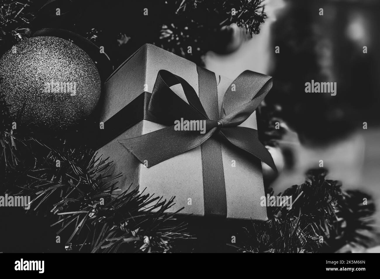 Weihnachtliche minimalistische Komposition in monochromer Form. Weihnachtsbaum Geschenke, Dekorationen auf schwarzem Hintergrund. Stockfoto