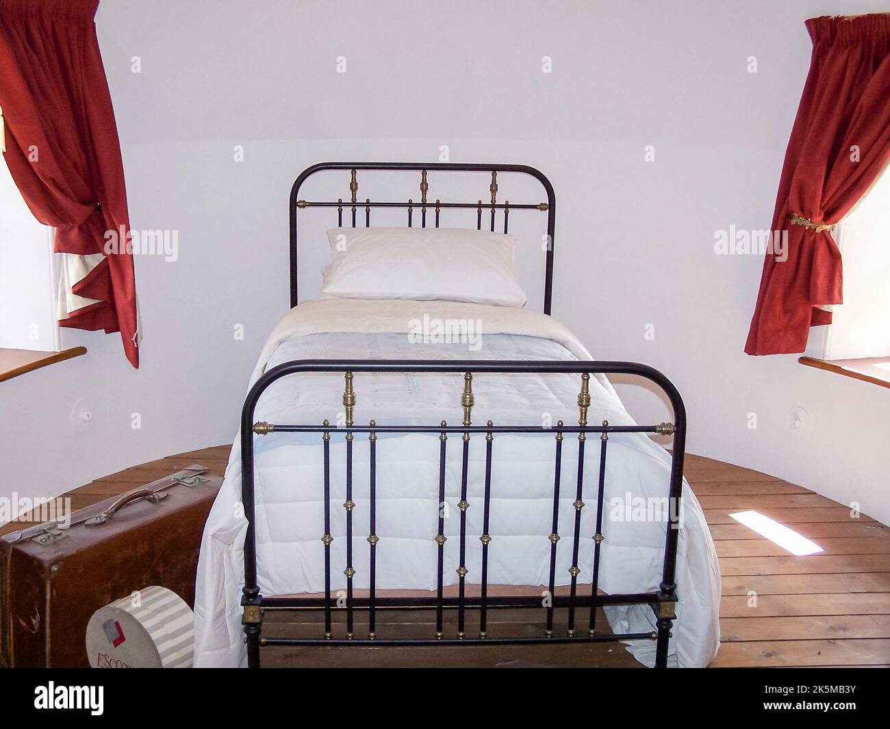Altmodisches viktorianisches Einzelbett aus Schmiedeeisen in einem runden Schlafzimmer Stockfoto