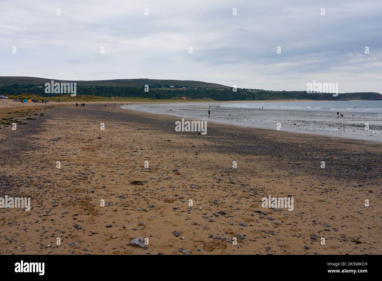 An einem kalten und grauen Sommernachmittag besuchen nur wenige Urlauber den Strand von Oxwich. Stockfoto