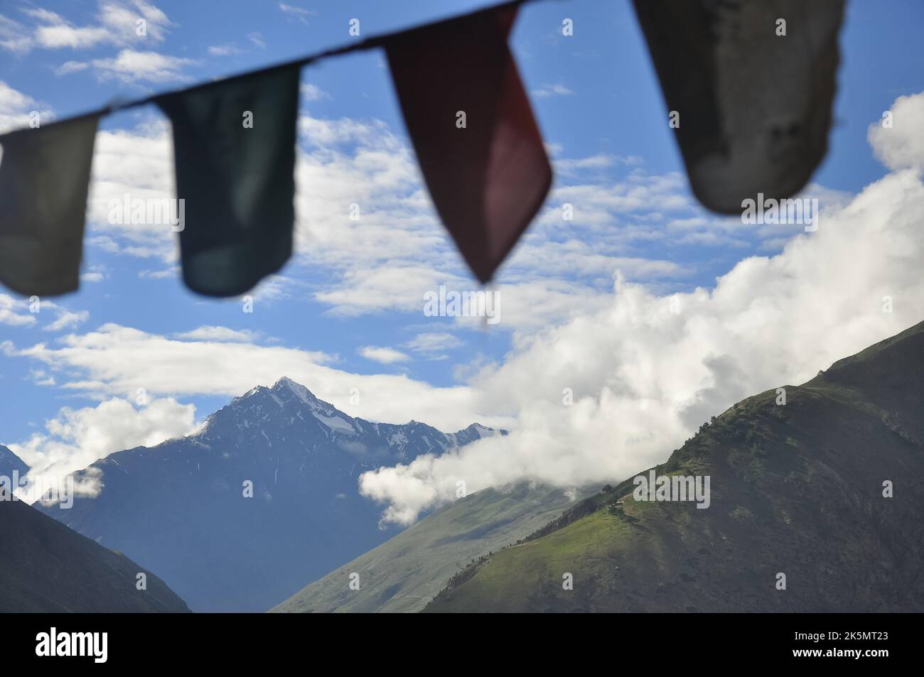 Selektiver Fokus auf den wunderschönen Blick auf die Berge bedeckt mit Wolken am Morgen mit tibetischen Flaggen Stockfoto