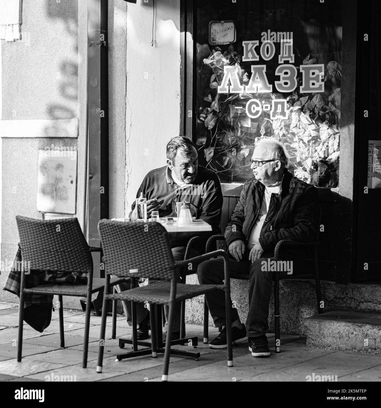 Die beiden alten Männer plaudern vor dem Café Stockfoto