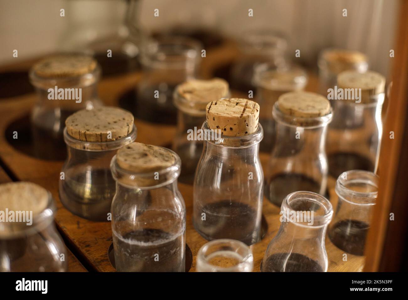Details zur geringen Schärfentiefe (selektiver Fokus) mit verschiedenen Glasfläschchen, die für alte chemische und medizinische Experimente in einem Museum verwendet werden. Stockfoto
