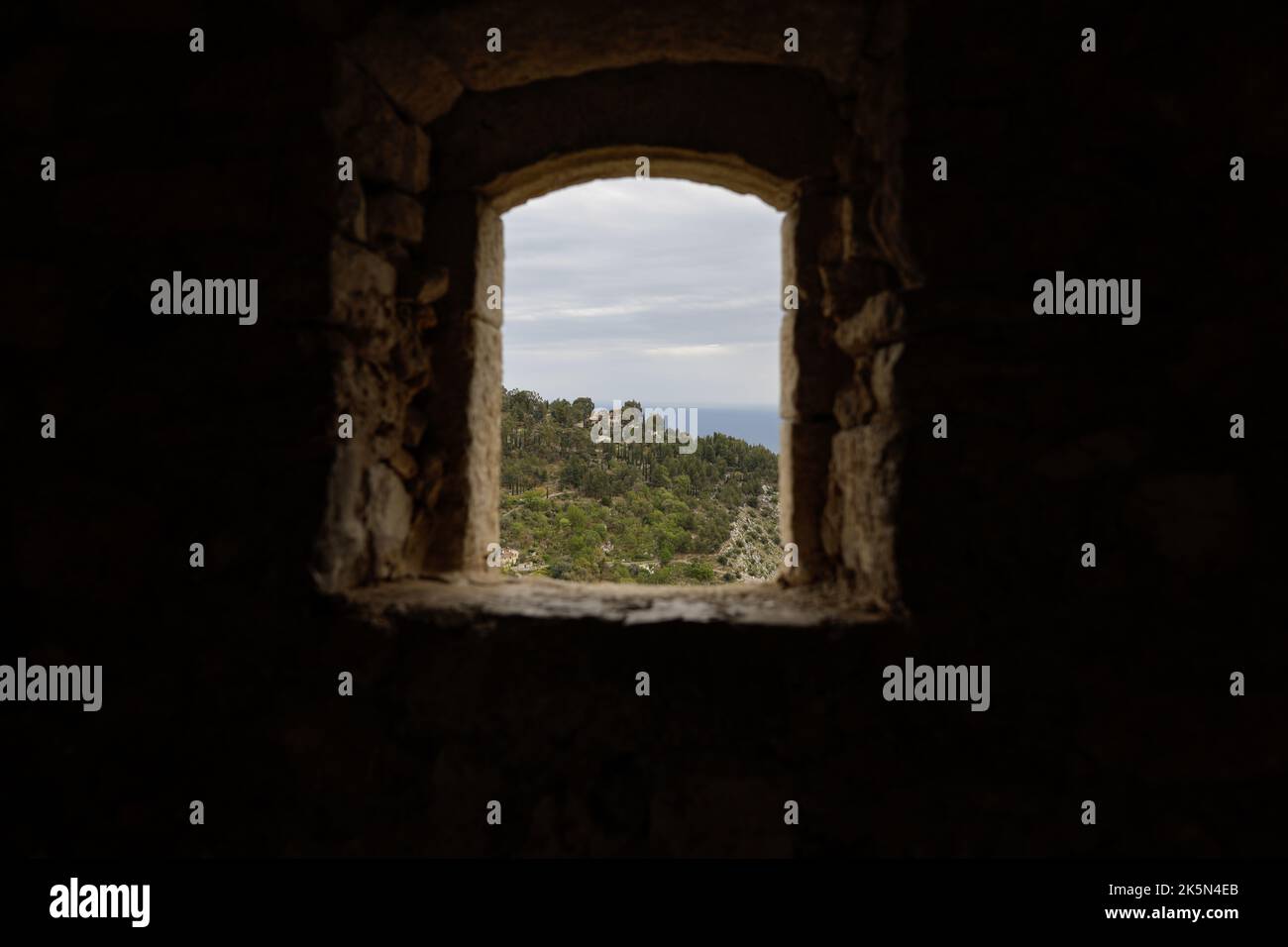 Details mit dem Blick aus einem Fenster in eine mittelalterliche Festung an der Französischen riviera während eines bewölkten Frühlingstages. Stockfoto