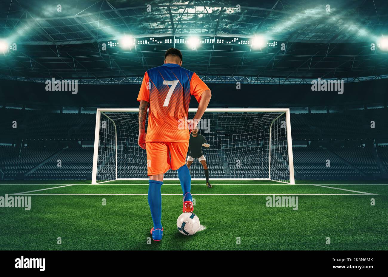 Fußballszene in der Nacht Spiel mit Spieler in orange Uniform tritt den Elfmeterstoß Stockfoto