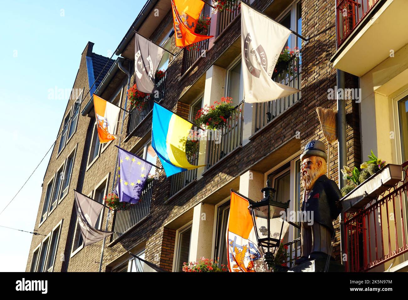 Vor einem Restaurant in der Düsseldorfer Altstadt stehen verschiedene lokale und internationale Flaggen. Stockfoto