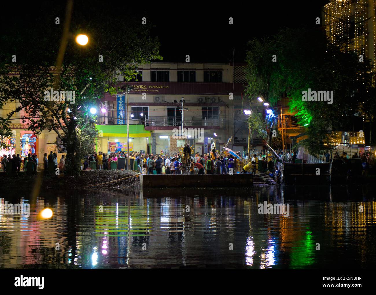 Immersion Ghat. Durga puja Vijayadashami, auch bekannt als Dussehra, Dasara. Prozession vor den Tonstatuen, die zum Abschied ins Wasser getaucht werden. Stockfoto