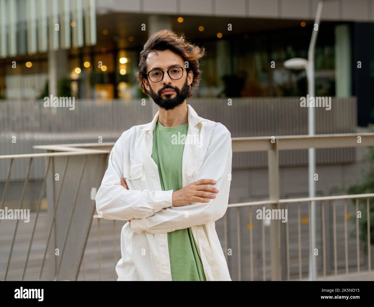 Junger Mann des digitalen Unternehmers, der in einer Stadt ernsthaft auf die Kamera schaut. Junger, tausendjähriger Geschäftsmann Stockfoto