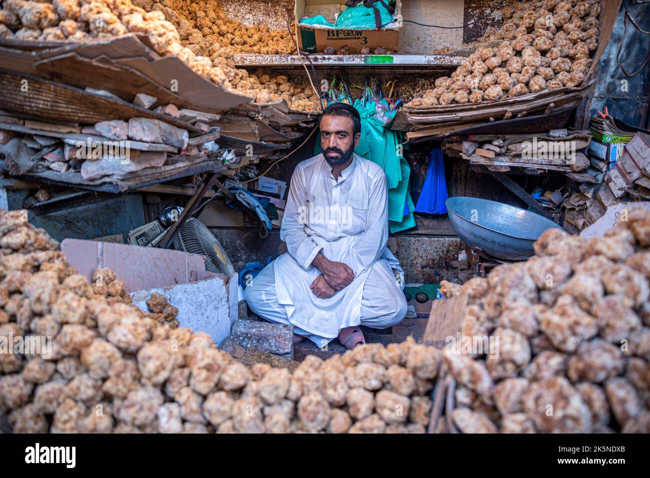 Ladenbesitzer, der braune natürliche Zuckerstückchen aus Zuckerrohren, Peshawar, Provinz Khyber Pakhtunkhwa, Pakistan, verkauft Stockfoto