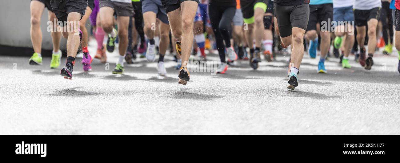 Läufer in Shorts und Sportschuhen starten einen Wettkampf, bei dem nur ihre Beine sichtbar sind. Stockfoto