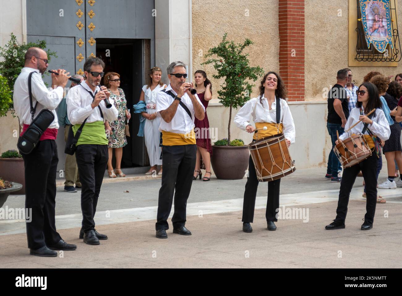 Musiker, die Akrobaten von Alicantes Muixeranga unterstützen und menschliche Pyramiden vor der Kirche Parroquia de San Pedro Apóstol in Rojales, Spanien, aufführen Stockfoto