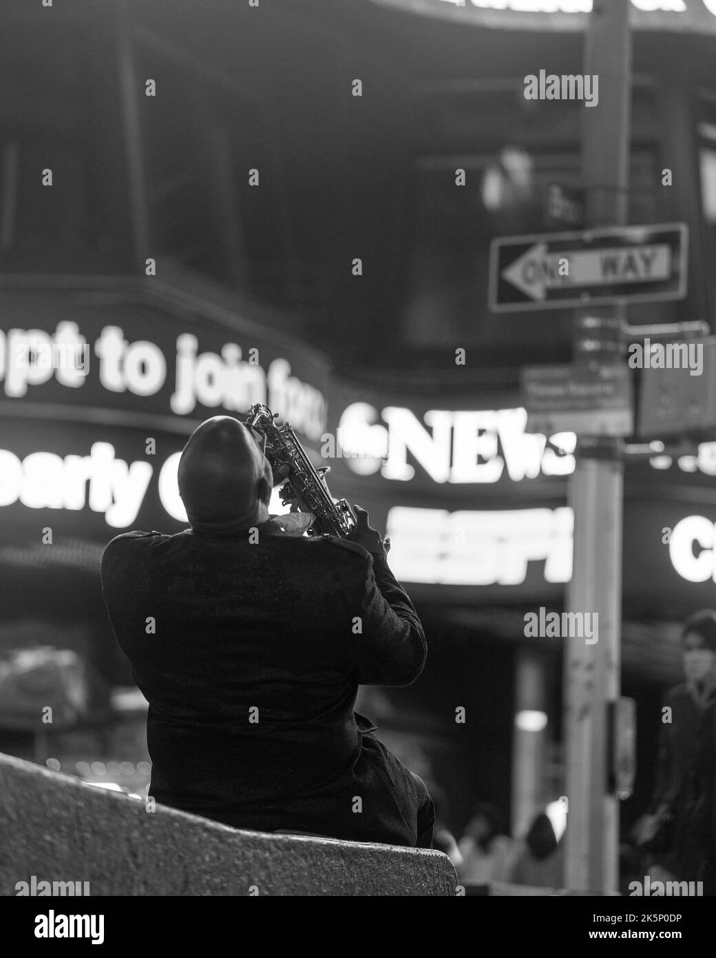 Ein Performer, der am Abend auf der Straße Saxophon spielt Stockfoto