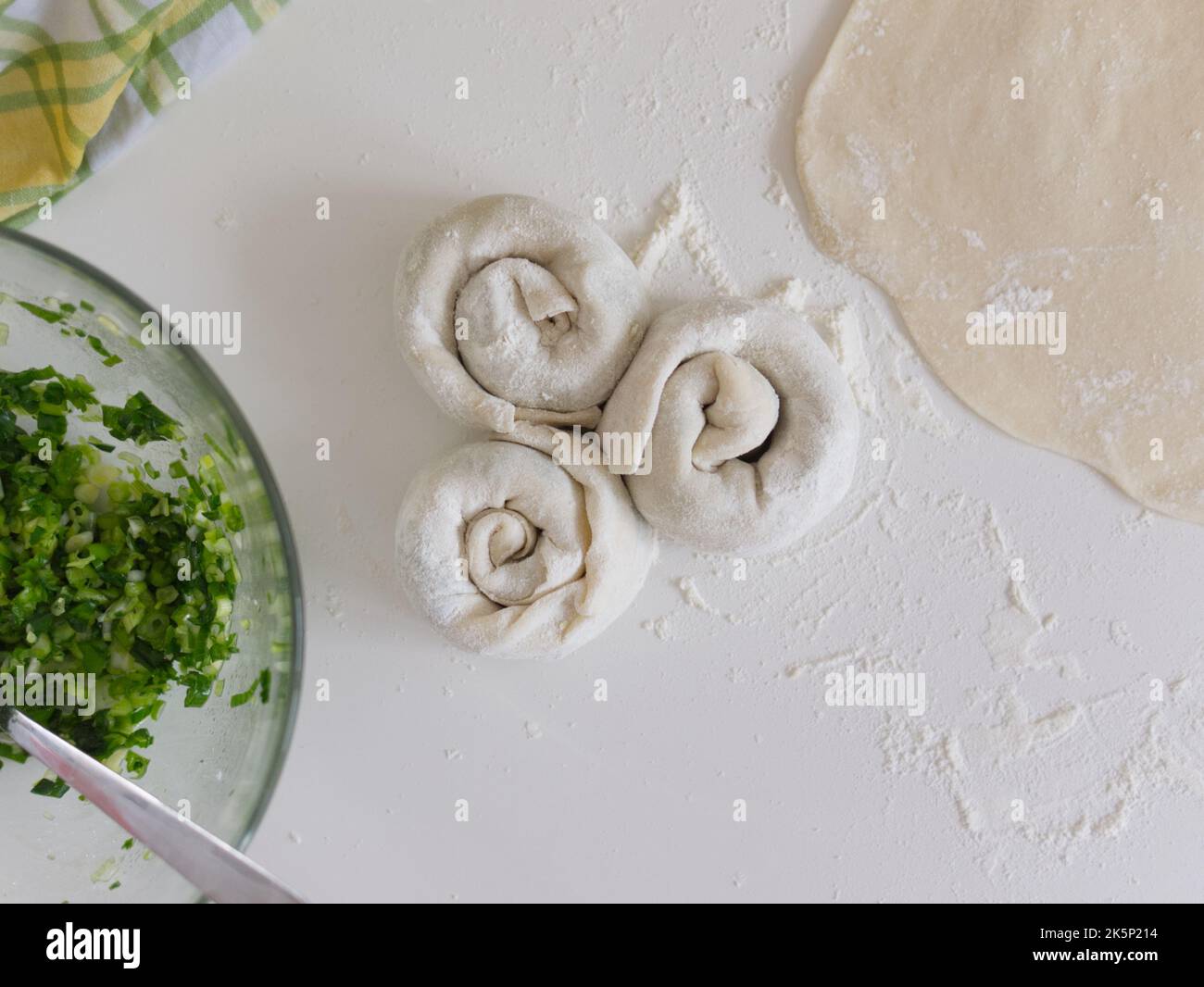 Chinesisches Essen in der Herstellung. Frühlingszwiebel-Pfannkuchen, ein traditionelles Gebäck, das die Menschen zu Hause herstellen. Stockfoto