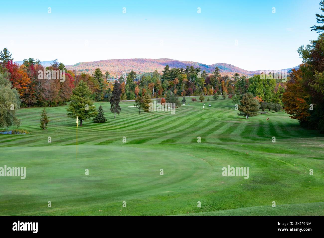 Ein Blick auf den Lake Pleasant Golf Club im Herbst mit leuchtend grünen Fairways und schönen Herbstlaub und Sahandaga Lake, wenn die Entfernung. Stockfoto