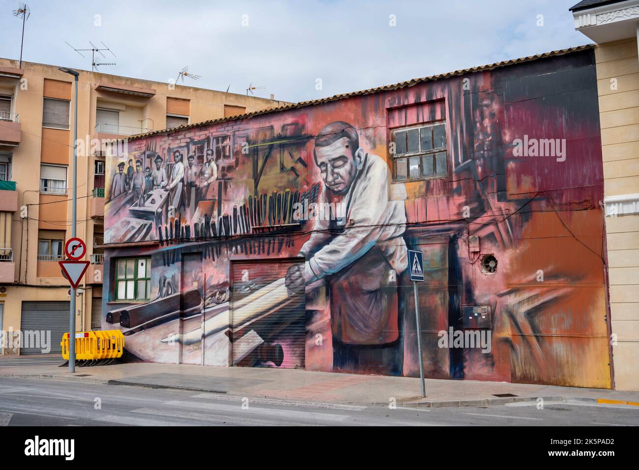 Großes Wandgemälde an der Seite eines Gebäudes in Rojales nach dem Rojales in Painting Festival, das zur Wiederbelebung verfallender Gebäude entworfen wurde. Workshop-Szene Stockfoto
