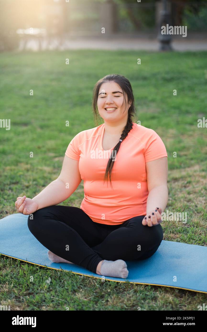 Yoga Üben Harmonie Balance übergewichtige Frau Park Stockfoto