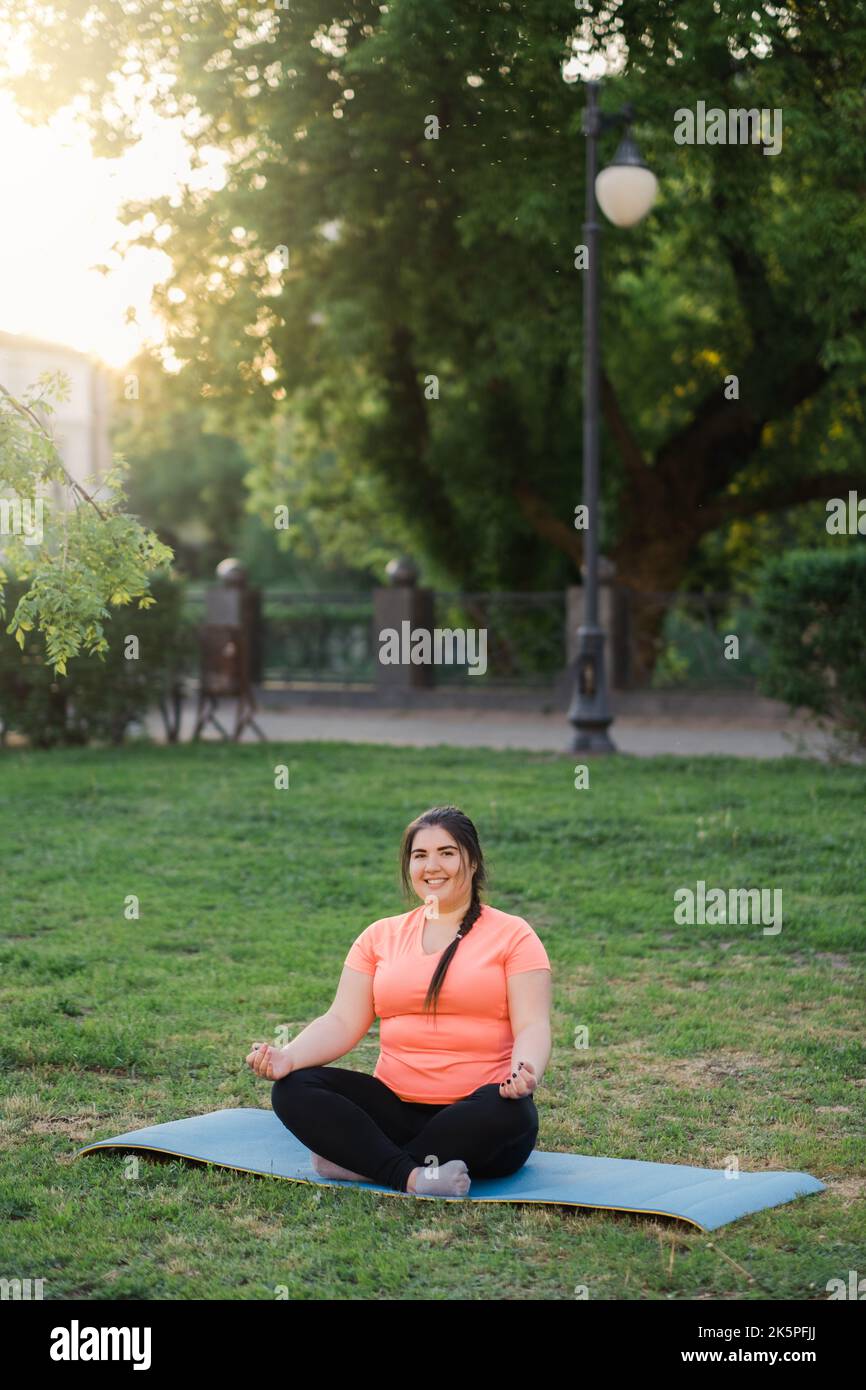 Yoga im Freien Geist Wellness Übergewicht Frau Park Stockfoto