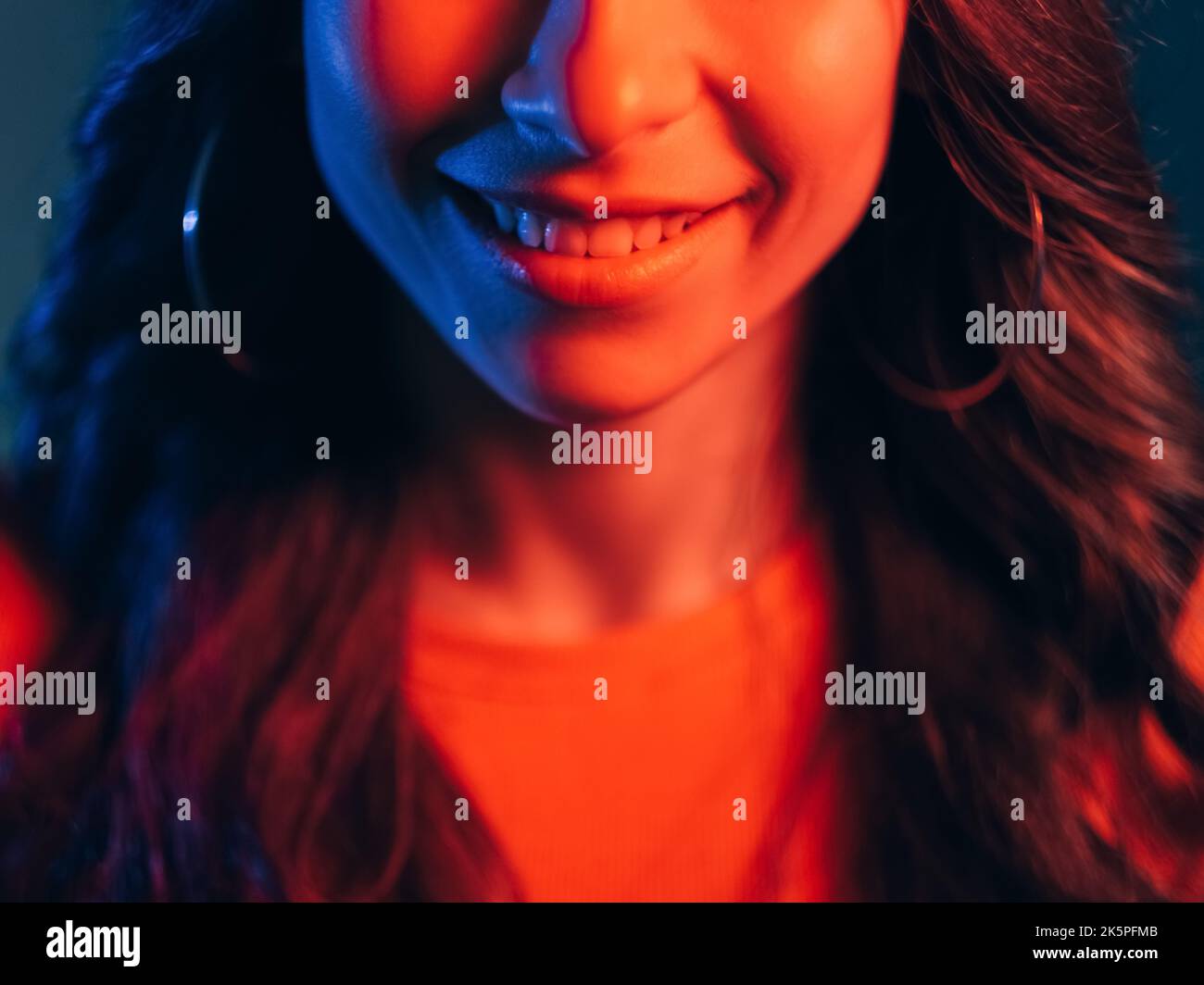 Neon Licht Lächeln positive Emotion Frau Gesicht rot Stockfoto