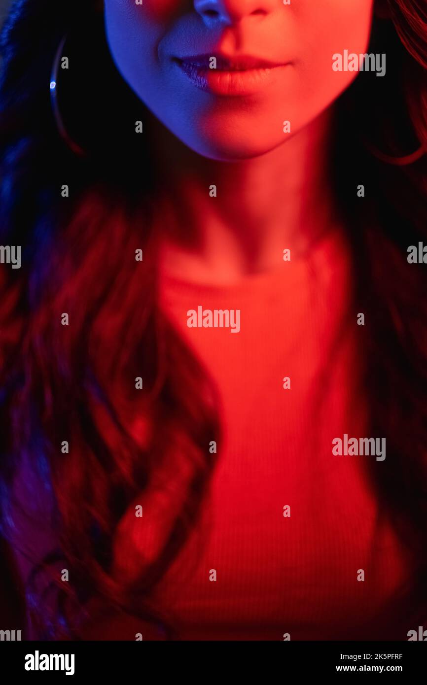 Lächelnde Frau Neon Licht Porträt Gesicht rote Farbe Stockfoto