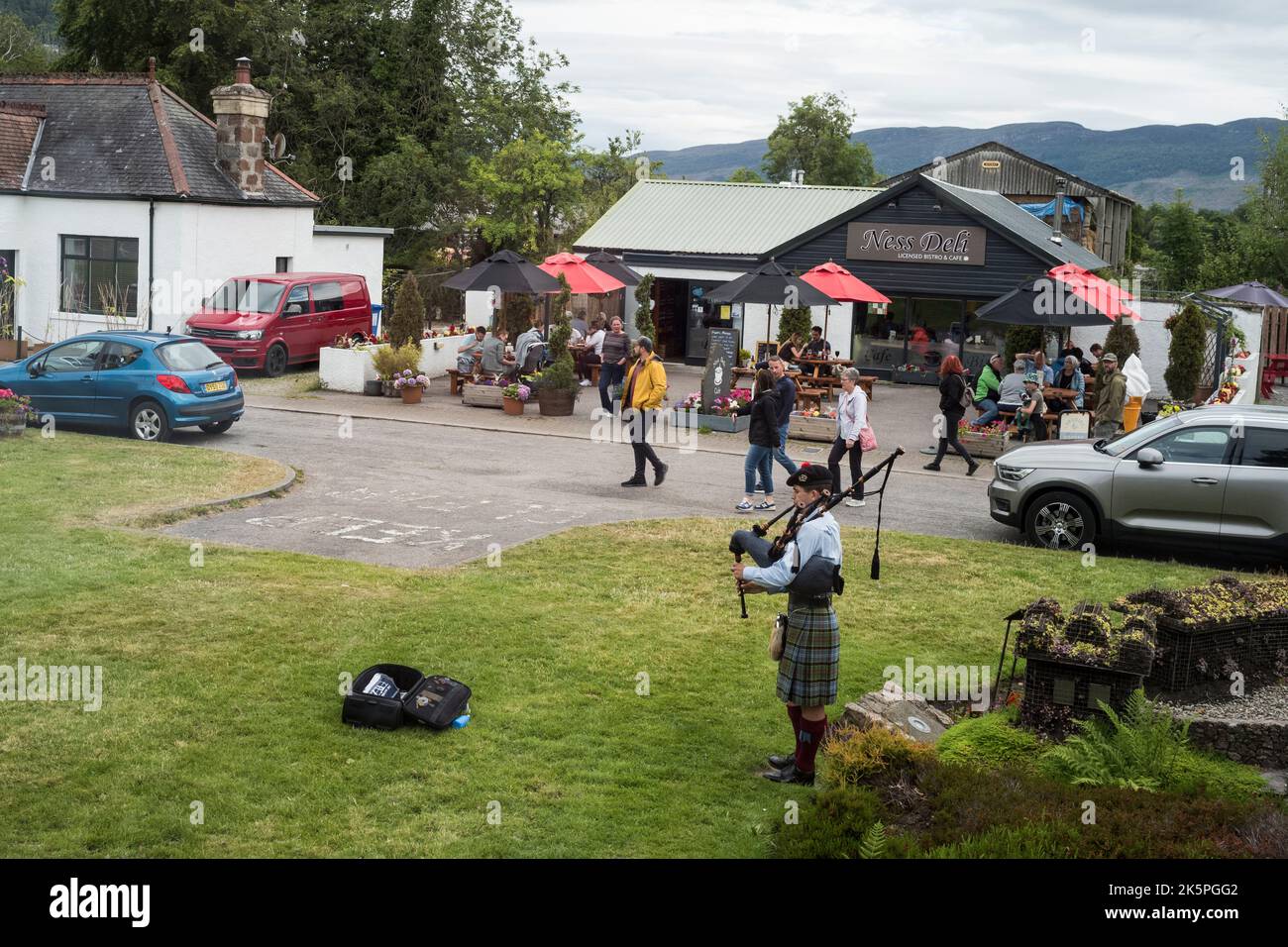 Piper und Touristen in Drumnadrochit bei Loch Ness, Schottland Stockfoto