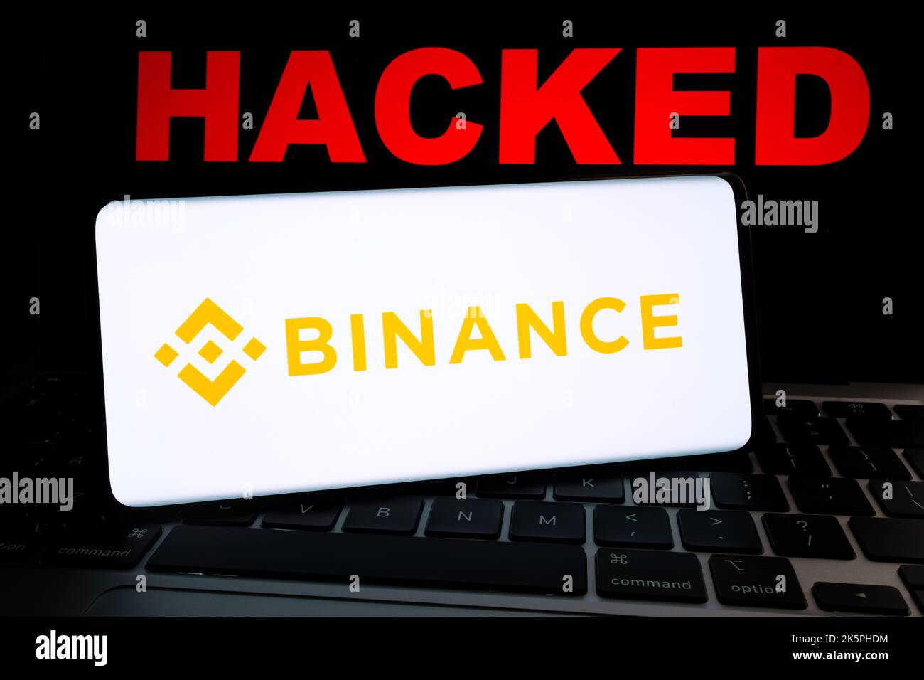 Binance-Kryptoaustausch gehackt. Binance-Logo auf Smartphne und roter Text „GEHACKT“ auf Laptop. Konzept. Stafford, Großbritannien, 9. Oktober 202 Stockfoto