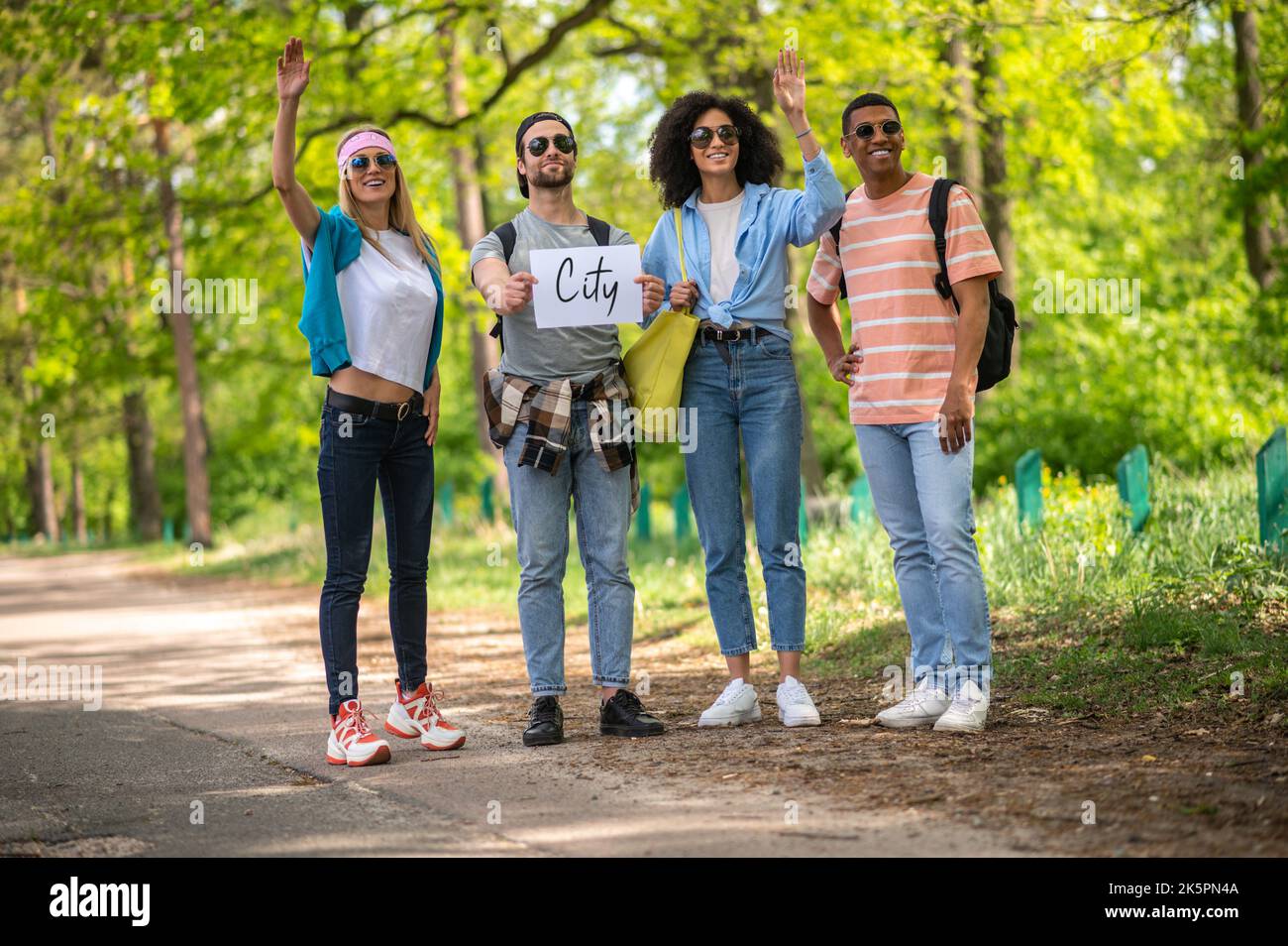 Junge Leute, die hitchwandern und aufgeregt sind Stockfoto