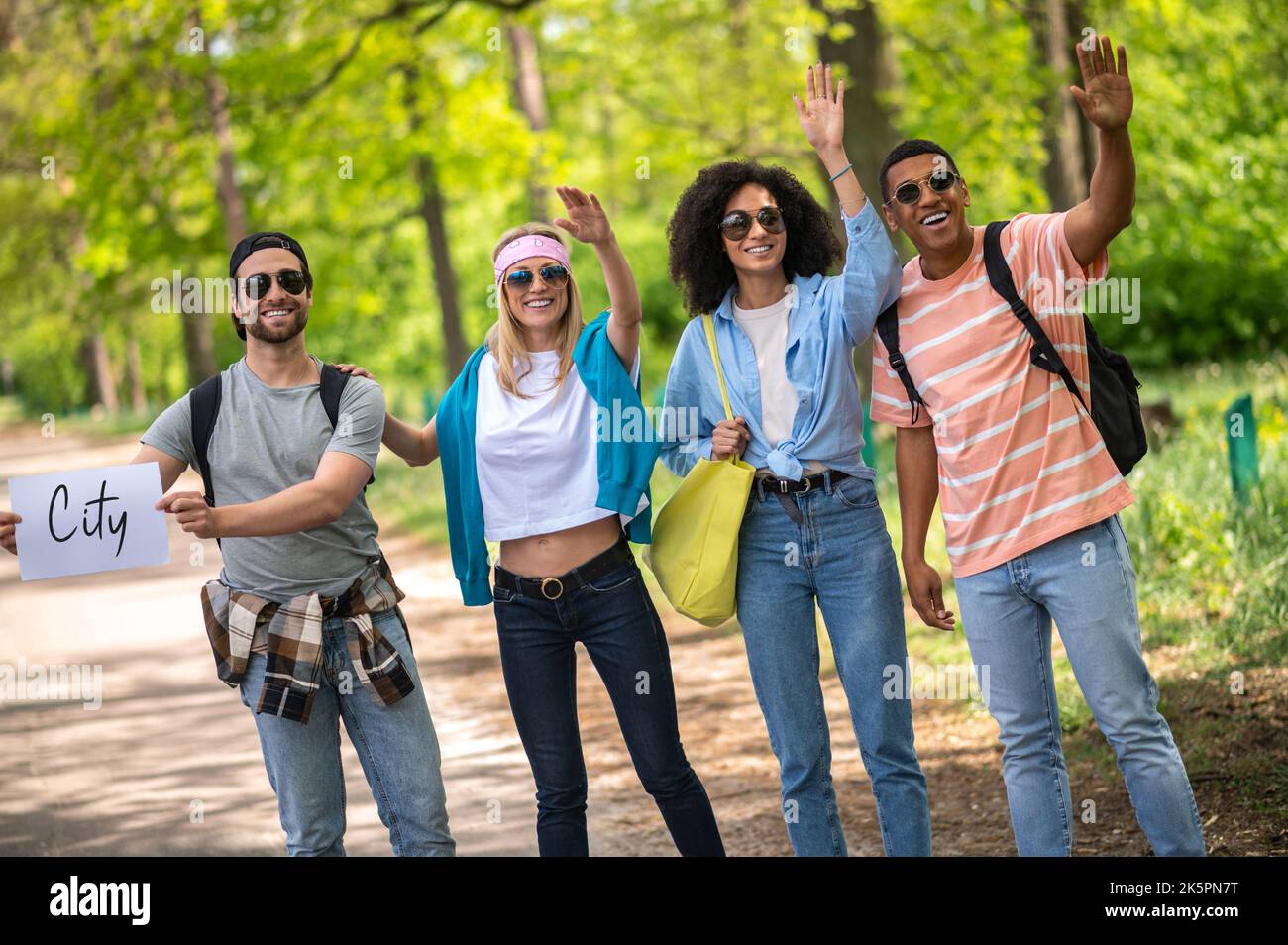 Junge Leute, die hitchwandern und aufgeregt sind Stockfoto