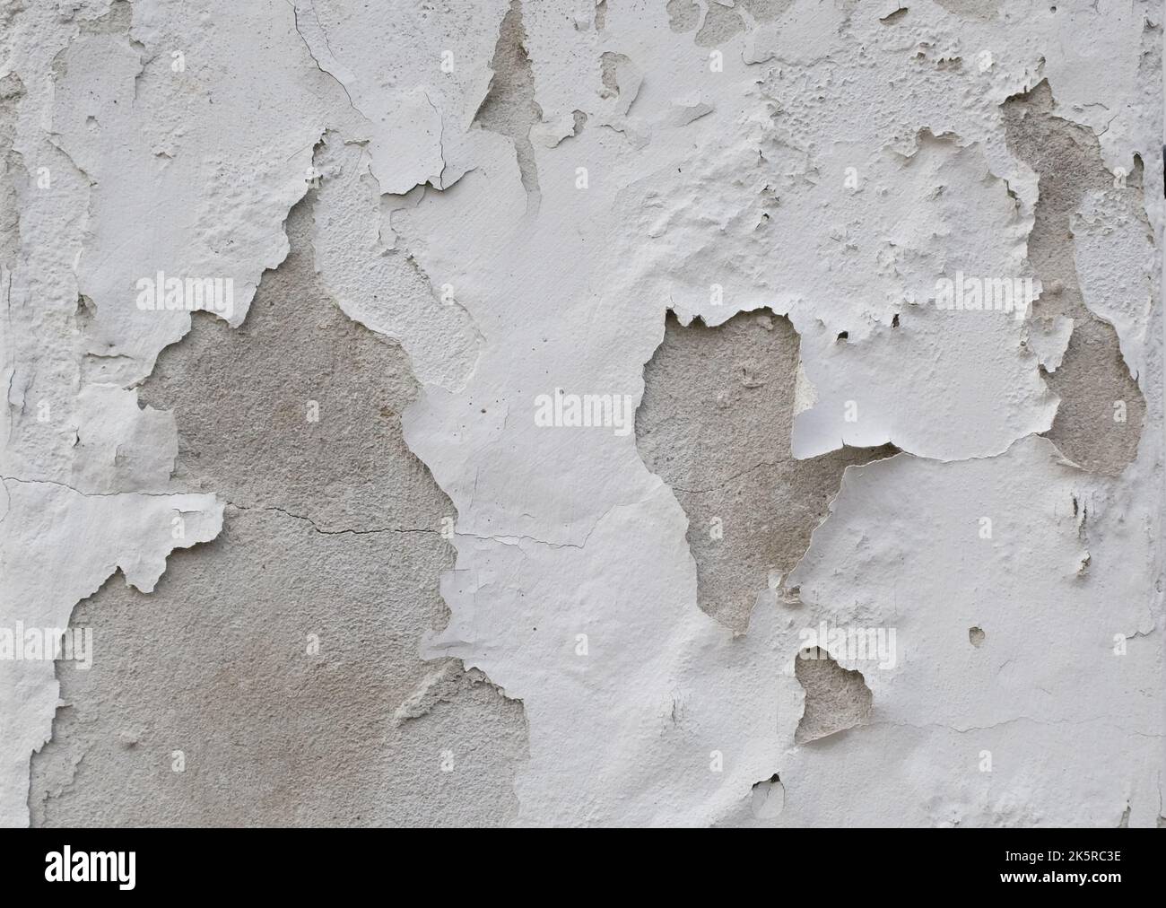 Hintergrund der abblätternden weißen Farbe an einer alten Wand. Stockfoto