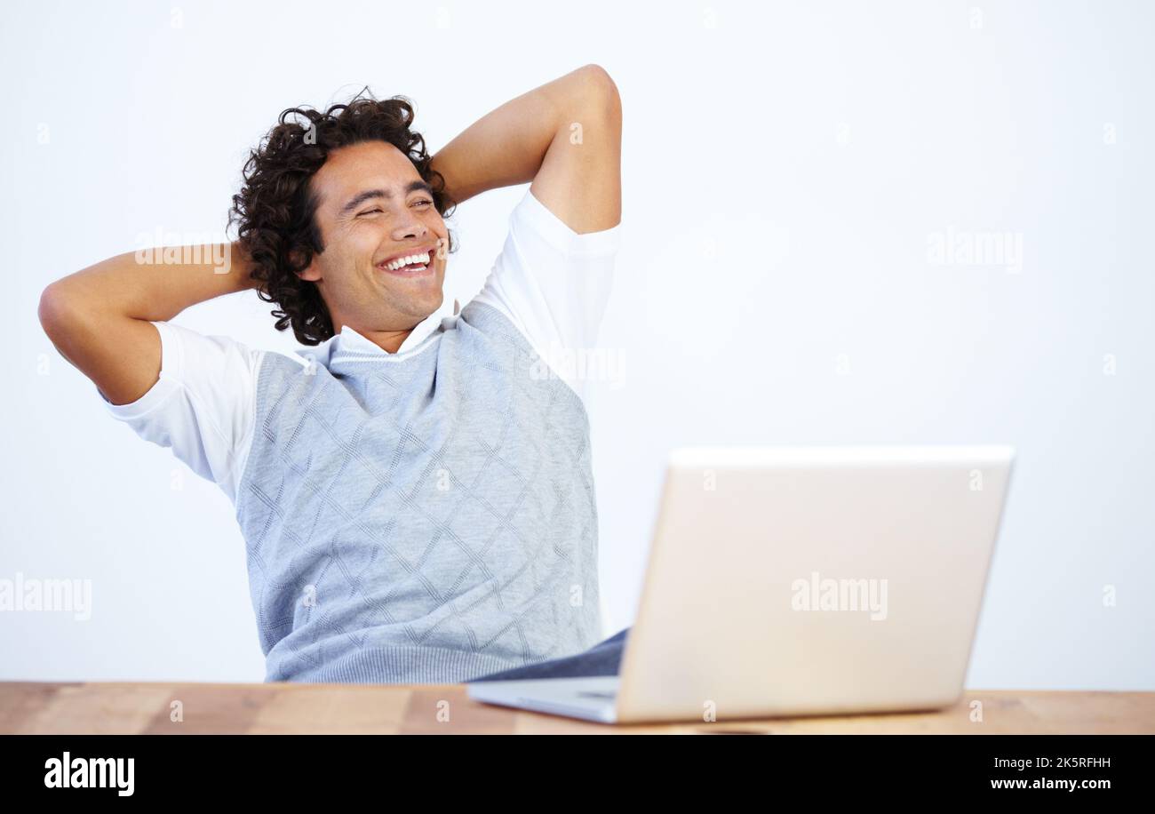 Zufrieden mit einem Job Gut gemacht. Ein entspannter Geschäftsmann, der sich mit einem Laptop zurücklehnen und wegschauen lässt. Stockfoto