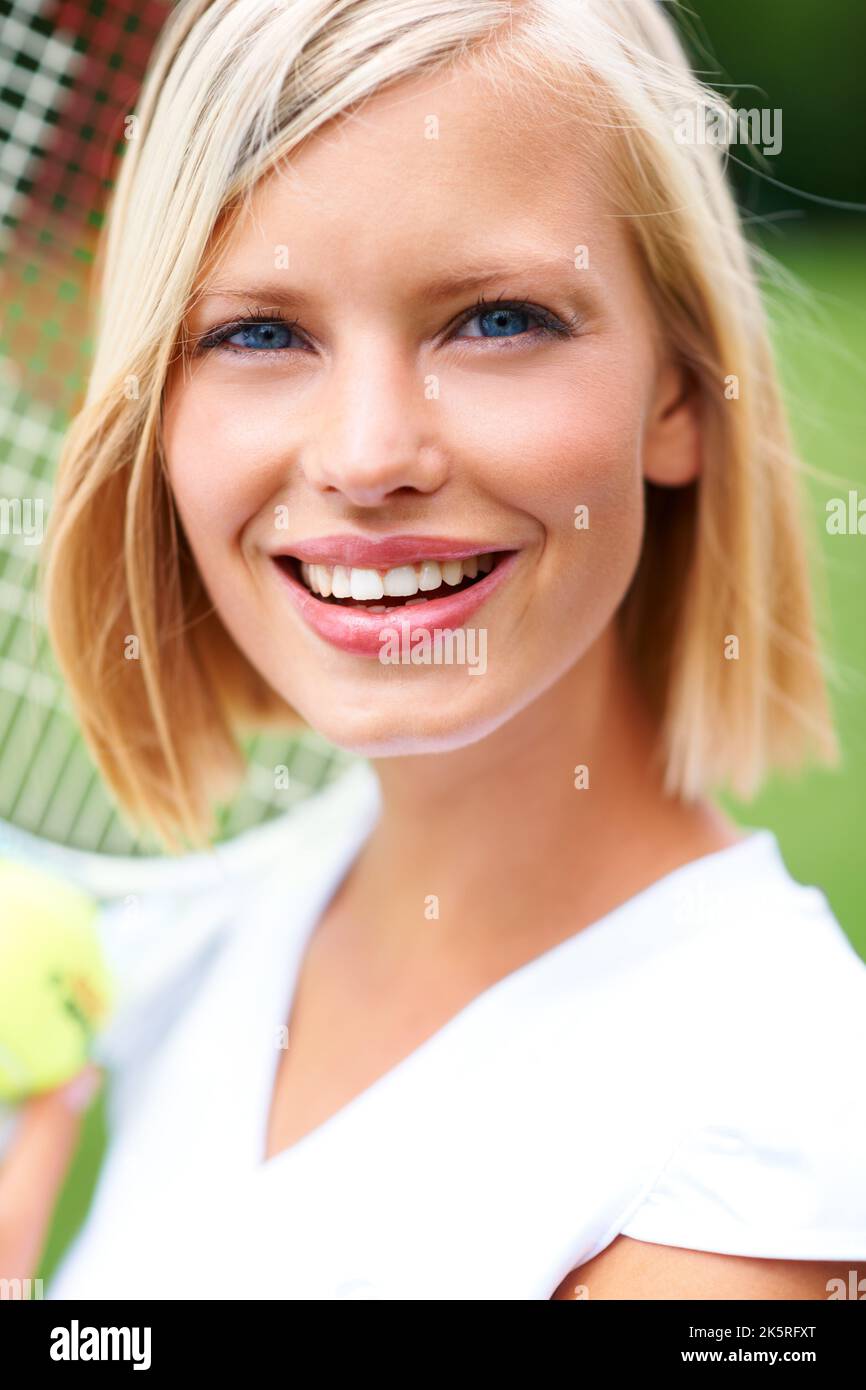 Ziemlich konkurrenzfähig. Porträt einer jungen Tennisspielerin mit Ball und Schläger. Stockfoto