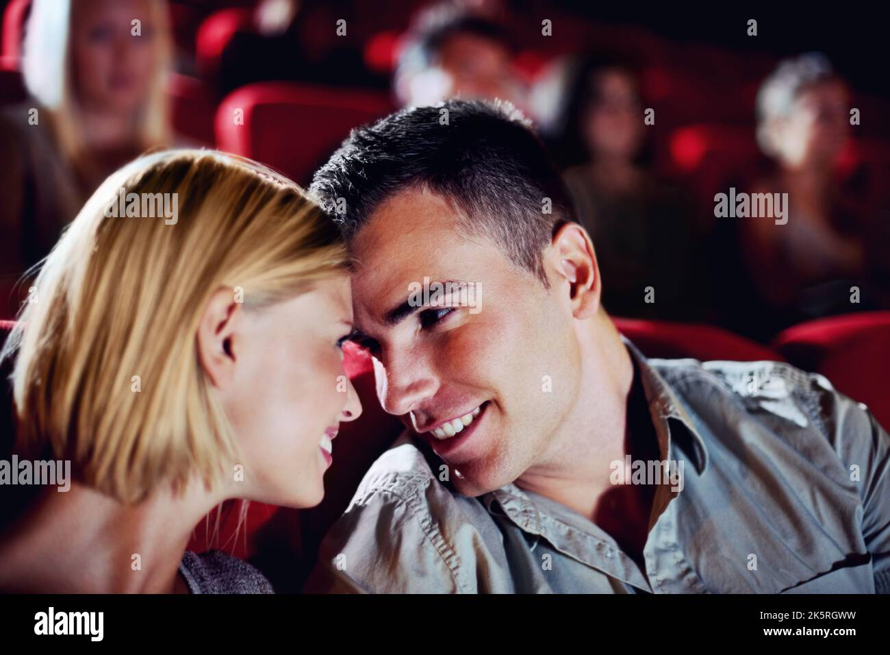 Romantische Komödie. Ein junges Paar auf einem Date in den Filmen, um einen Kuss zu teilen. Stockfoto