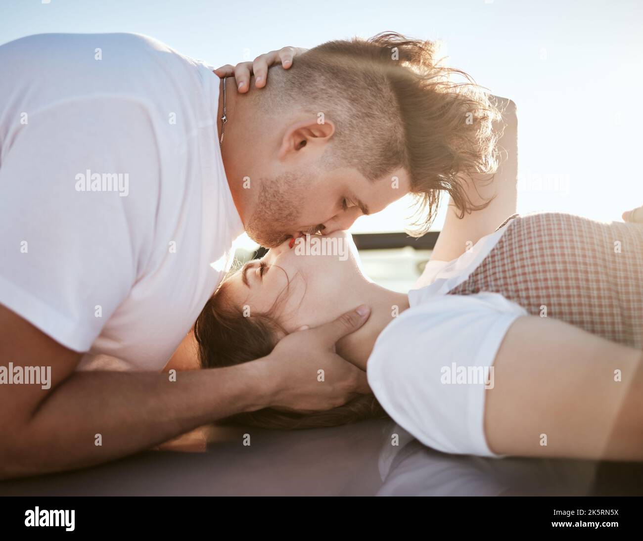 Liebe, Intimität und Paar küssen und entspannen sich gemeinsam im Freien, Lippen berühren und Spaß haben. Romantik, Flirten und Zuneigung von jungen Männern und Frauen Stockfoto