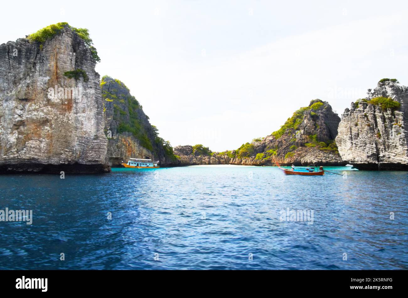 Verstecktes Paradies. Panoramablick auf wunderschöne geheime Inseln mit felsigen Klippen, wenn zwei Boote vorbeifahren - Copyspace. Stockfoto