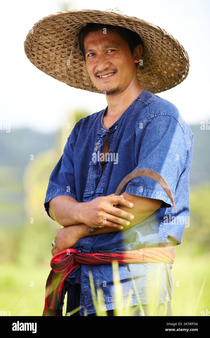 Porträt eines Reisplantagenarbeiters mit einer Sense - Thailand Stockfoto