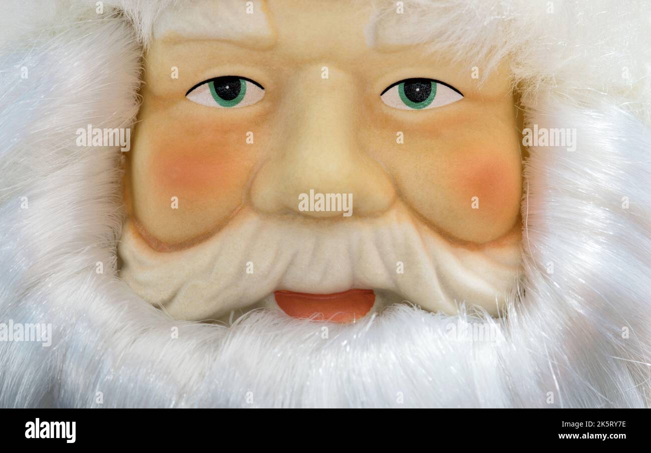 Santa Claus dekorative Puppe Nahaufnahme mit Gesichtszüge und Details, Blick auf die Kamera. Umrahmt von weißem Bart und Haaren. Stockfoto