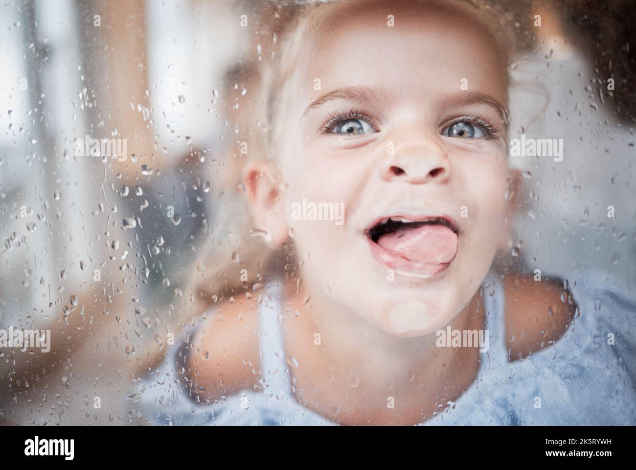 Lustig, Kind und Zunge auf Fensterportrait mit goofy und enthusiastischen Gesicht auf die Oberfläche gedrückt. Junges, glückliches und verrücktes Mädchen, das verspielt leckt Stockfoto