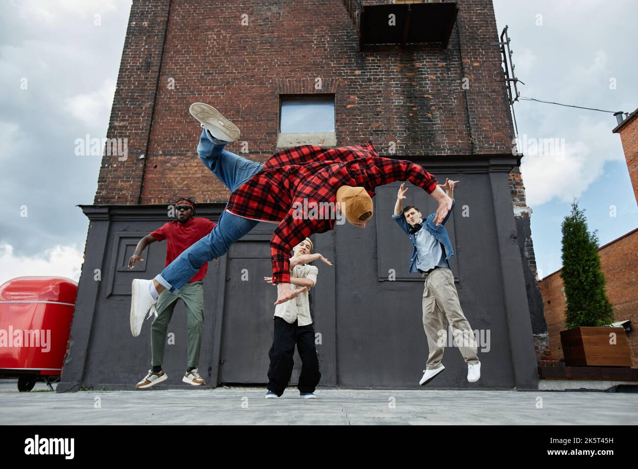 Action-Aufnahme aller männlichen Breakdance-Teams, die Sprünge in städtischen Ballungsgebieten machen Stockfoto