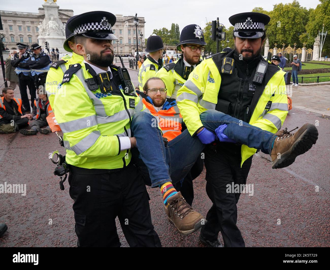 Polizeibeamte entfernen einen Aktivisten aus einem Just Stop Oil-Protest in der Mall, in der Nähe des Buckingham Palace, London. Aktivisten blockieren seit Anfang Oktober Straßen im Zentrum von London, als Teil ihrer Kampagne, zukünftige Gas- und Ölprojekte zu stoppen. Bilddatum: Montag, 10. Oktober 2022. Stockfoto