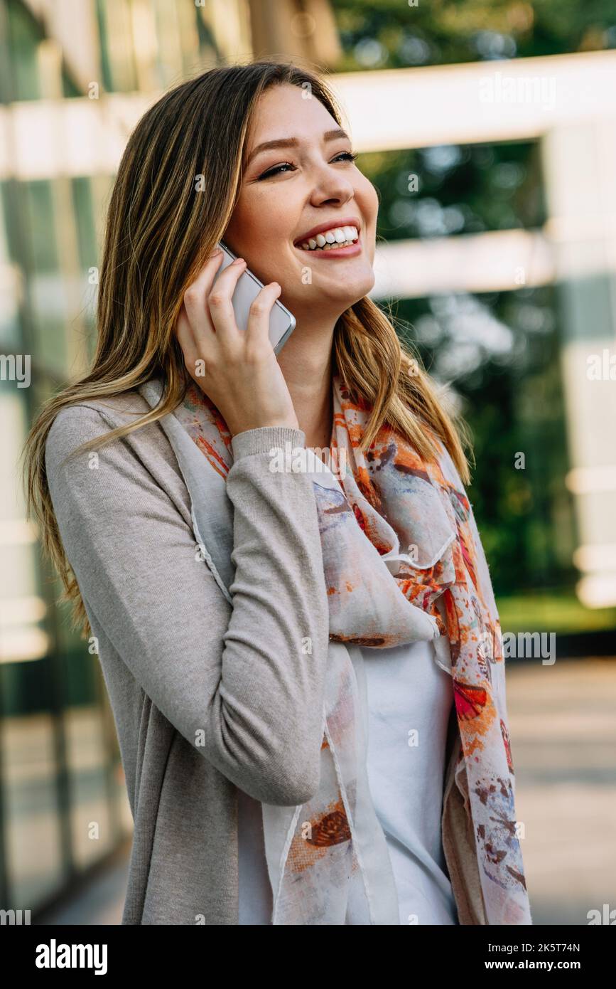 Schöne Geschäftsfrau mit Mobiltelefon im Freien. Konzept der Kommunikationstechnologie für Menschen. Stockfoto