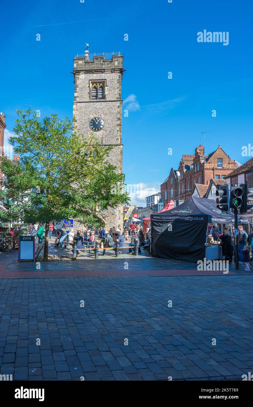Am Samstagmarkttag sind Leute unterwegs, einige machen eine Pause unter dem Uhrenturm. St Albans, Hertfordshire, England, Großbritannien Stockfoto