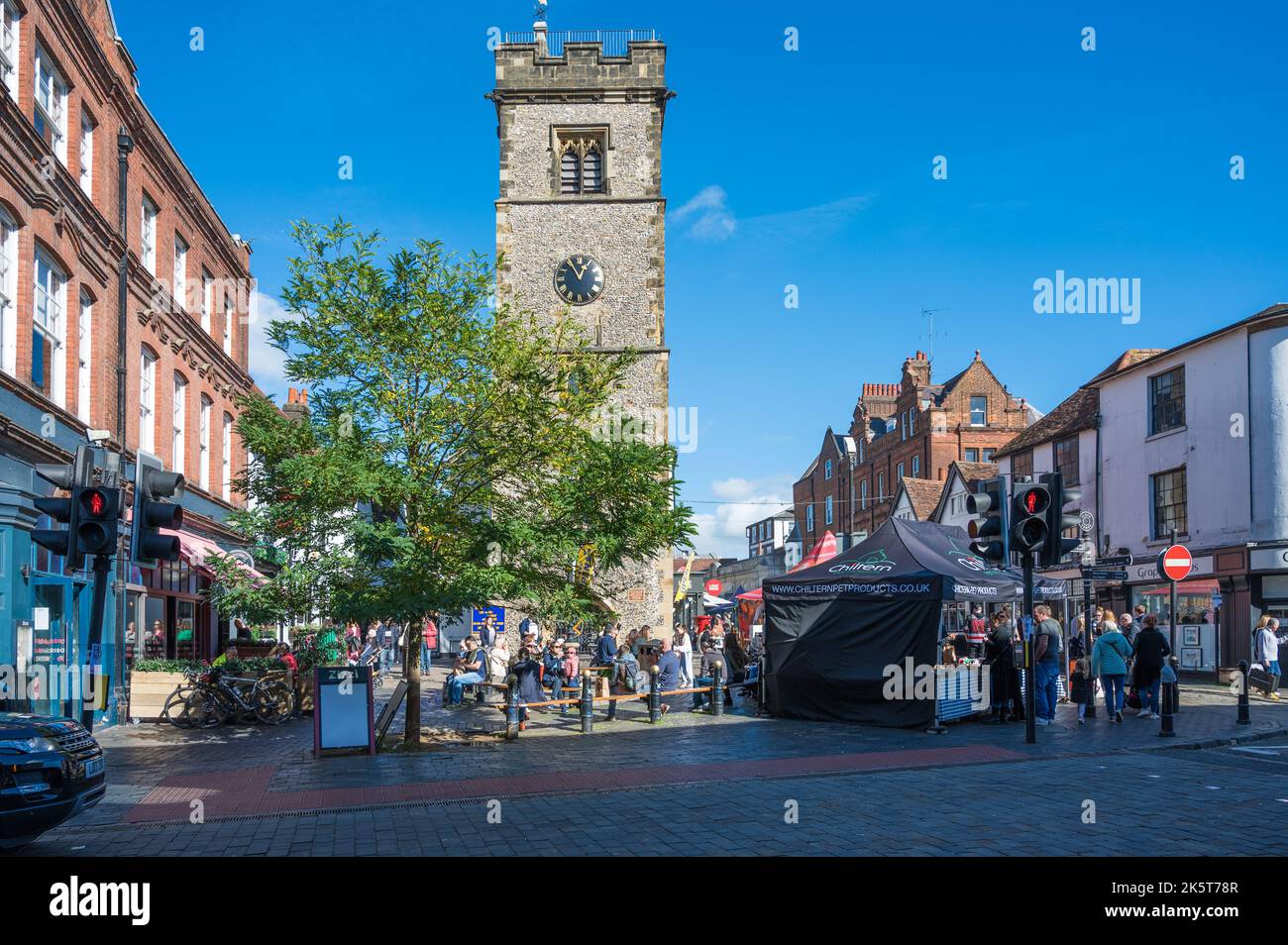 Am Samstagmarkttag sind Leute unterwegs, einige machen eine Pause unter dem Uhrenturm. St Albans, Hertfordshire, England, Großbritannien Stockfoto