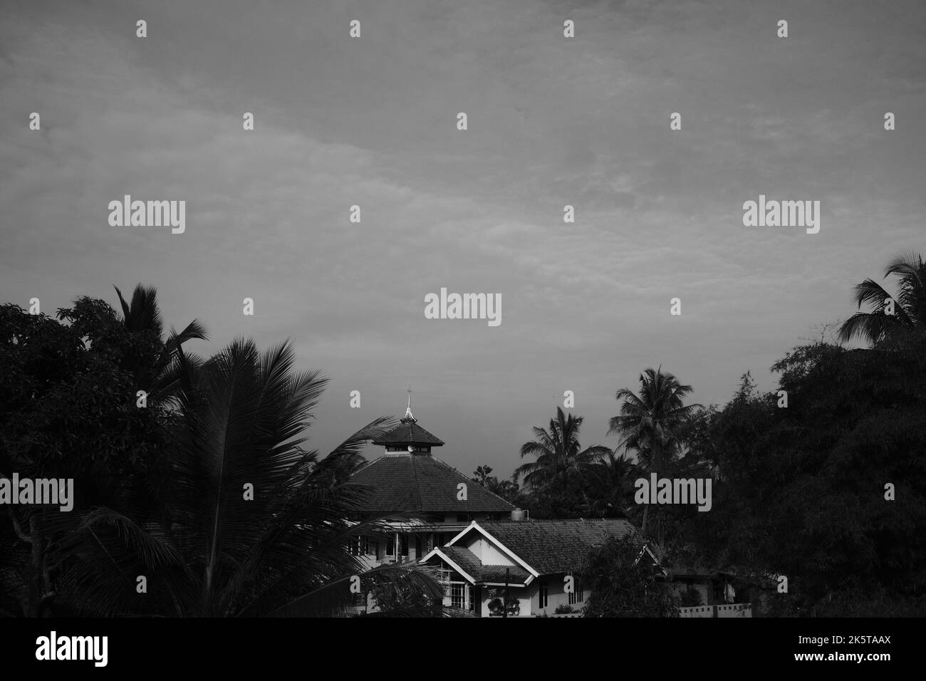 Abgelegene Moschee, monochrome Aufnahme eines Moschee-Gebäudes zwischen Häusern in der Cikancung-Gegend - Indonesien Stockfoto