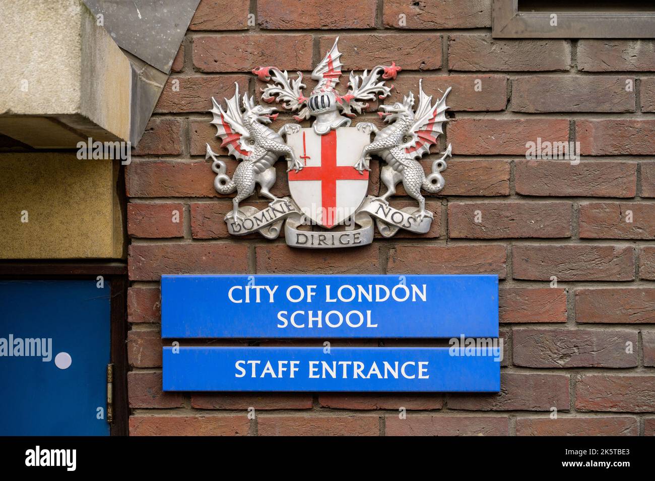 LONDON - 21. Mai 2022: Wappen, City of London School und Mitarbeitereingangsschilder an der Backsteinmauer Stockfoto