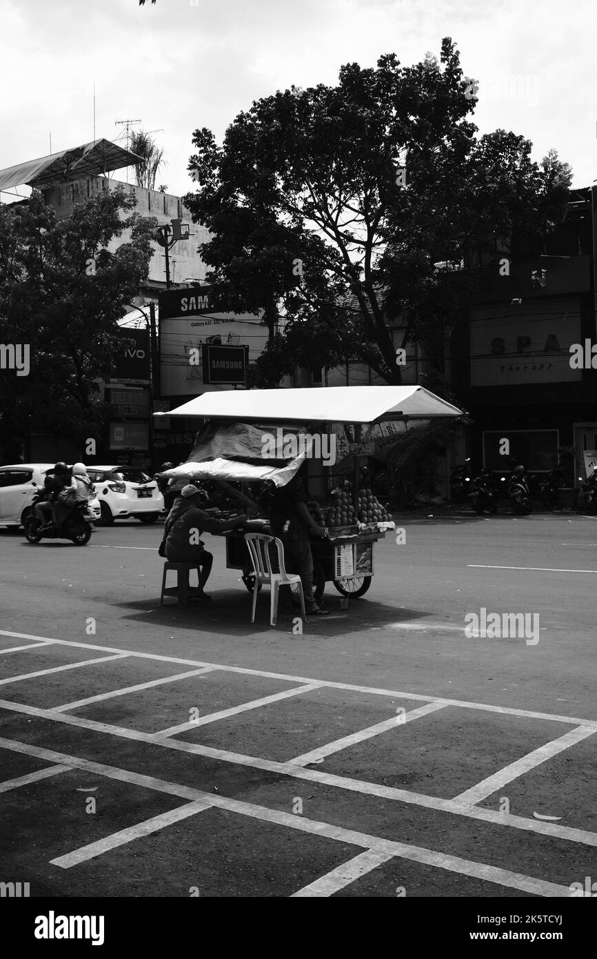 Bandung, West Java, Indonesien - 09. Oktober 2022 : Obsthändler, Monochromes Foto von Obsthändlern, die mitten auf der Autobahn verkaufen Stockfoto