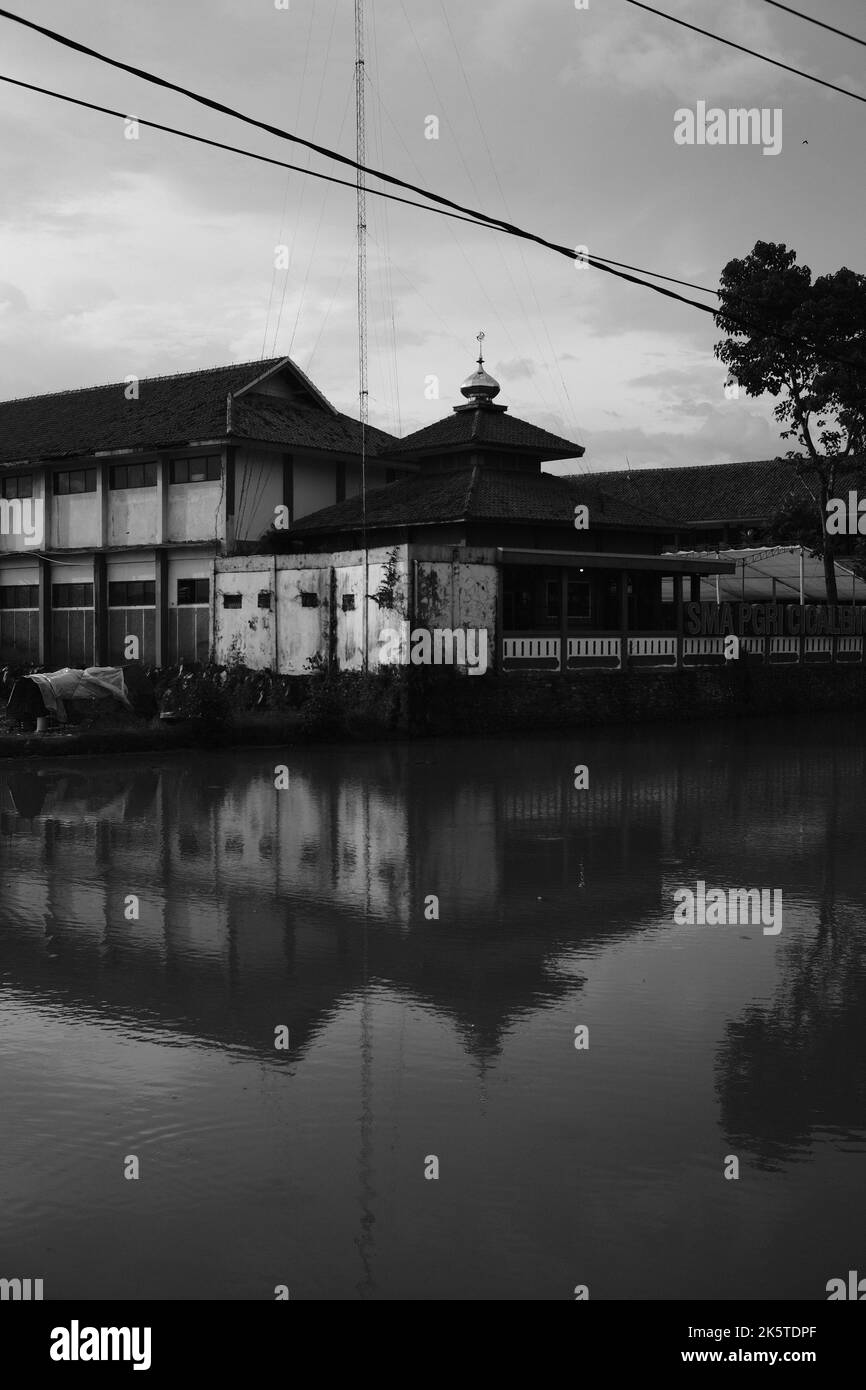 Spiegelung des Gebäudes, monochromes Foto der Spiegelung des Schattens der Moschee im Teich in der Cikancung-Region - Indonesien Stockfoto