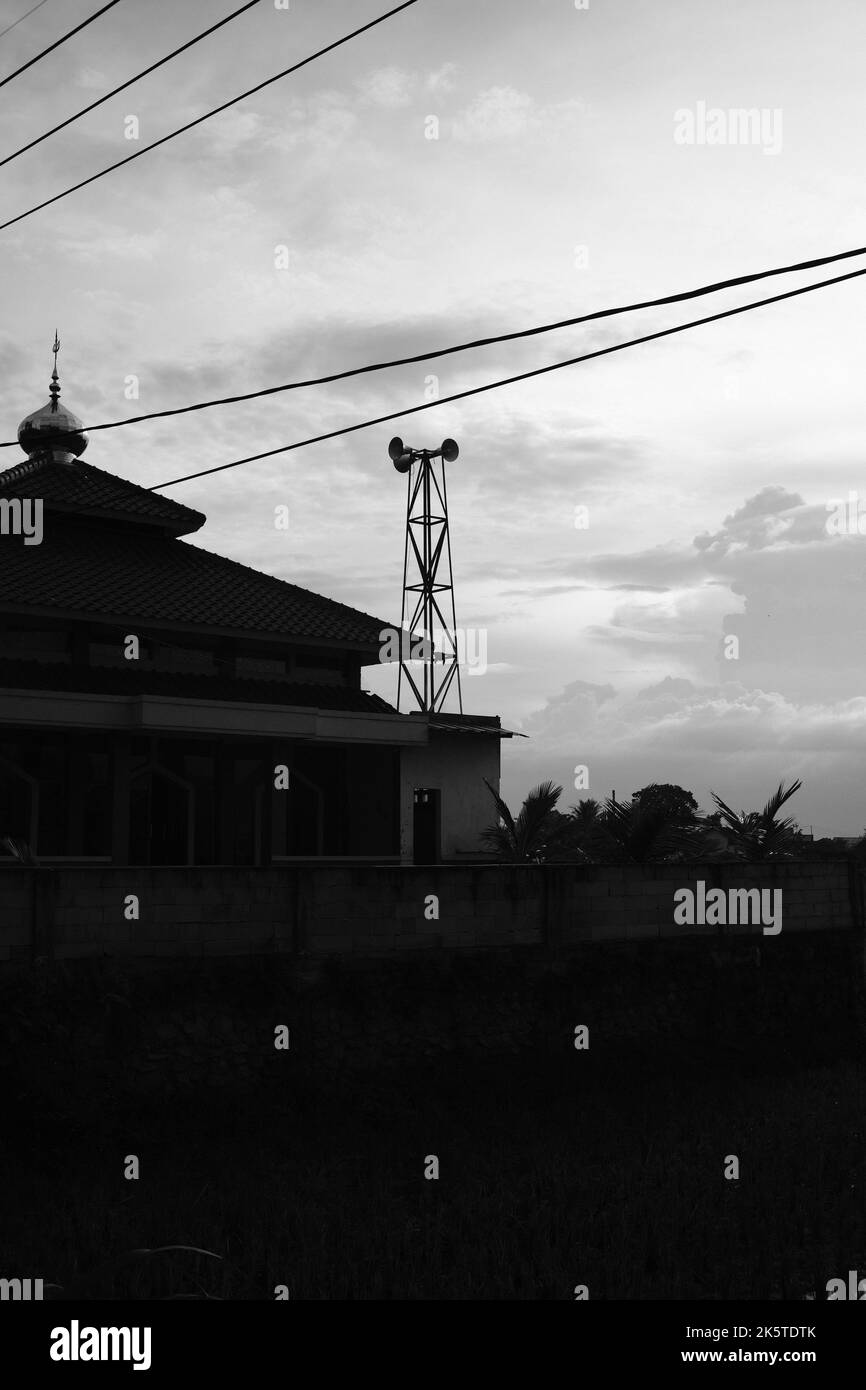 Moschee Silhouette, Silhouette Foto einer Moschee am Rande eines Reisfeldes im Cikancung-Gebiet - Indonesien Stockfoto
