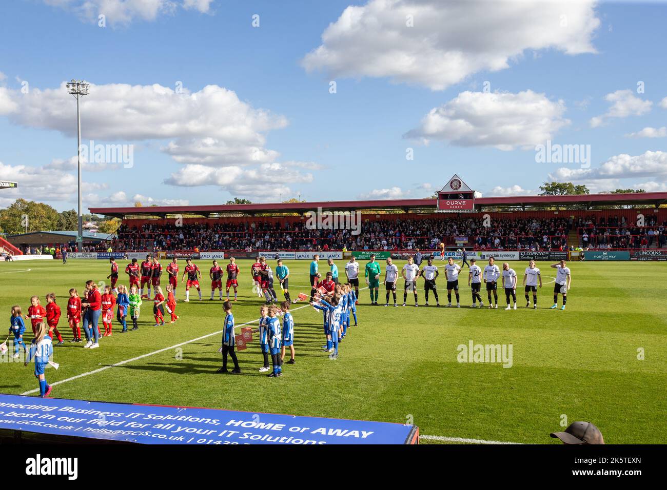Spieler und Beamte standen vor dem Spiel im Lamex Stadium an. Heimstadion des Stevenage Football Club Stockfoto