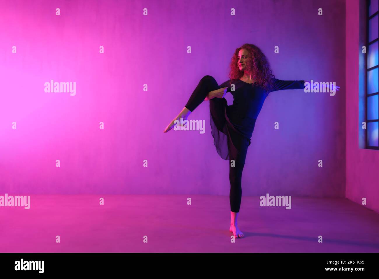 Moderner Tanz Mädchen Tänzerin tanzen in Neon-Licht dabei Gymnastik-Übungen im Studio, kopieren Raum. Stockfoto