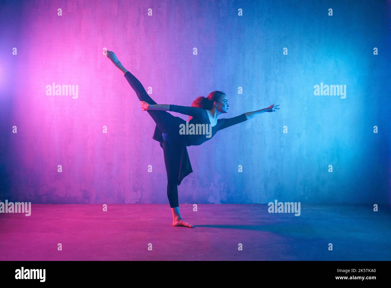 Moderner Tanz Mädchen Tänzerin tanzen in Neon-Licht dabei Gymnastik-Übungen im Studio, kopieren Raum. Stockfoto